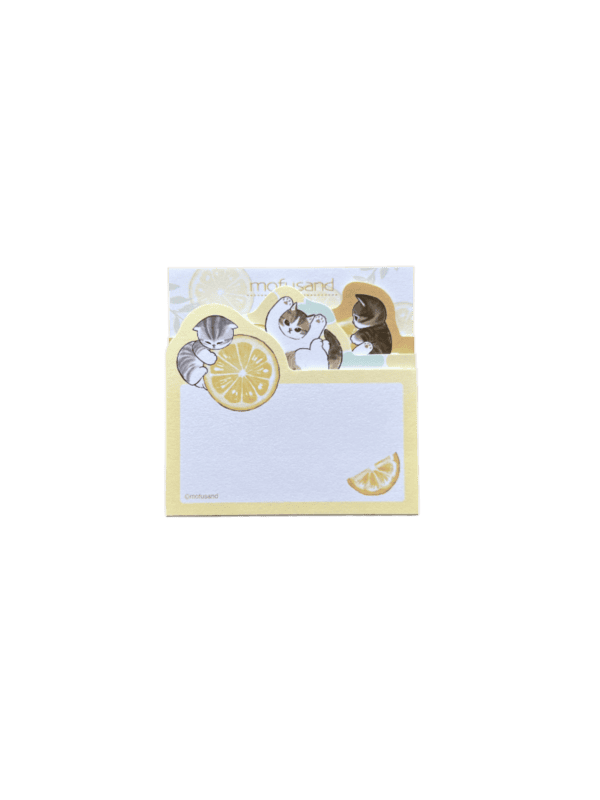 Front design view of the sticky memo block standing upright, showing layered die-cut tabs with kittens playing with lemon slices above a writeable memo pad decorated with a lemon wedge in the corner.