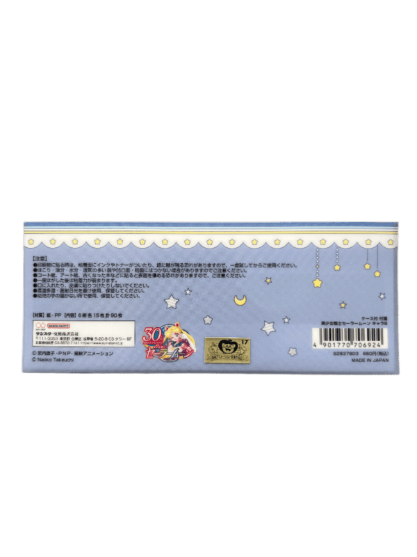 Back view of the pouch packaging displaying Japanese product care details, a 30th anniversary Sailor Moon logo sticker, a Toei Animation gold license seal, and a barcode on a light blue starry background.